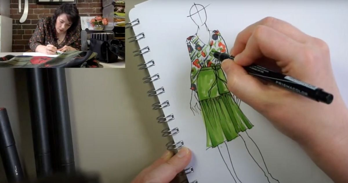 Fashion sketching a green dress in a notebook, with a view of the sketcher.